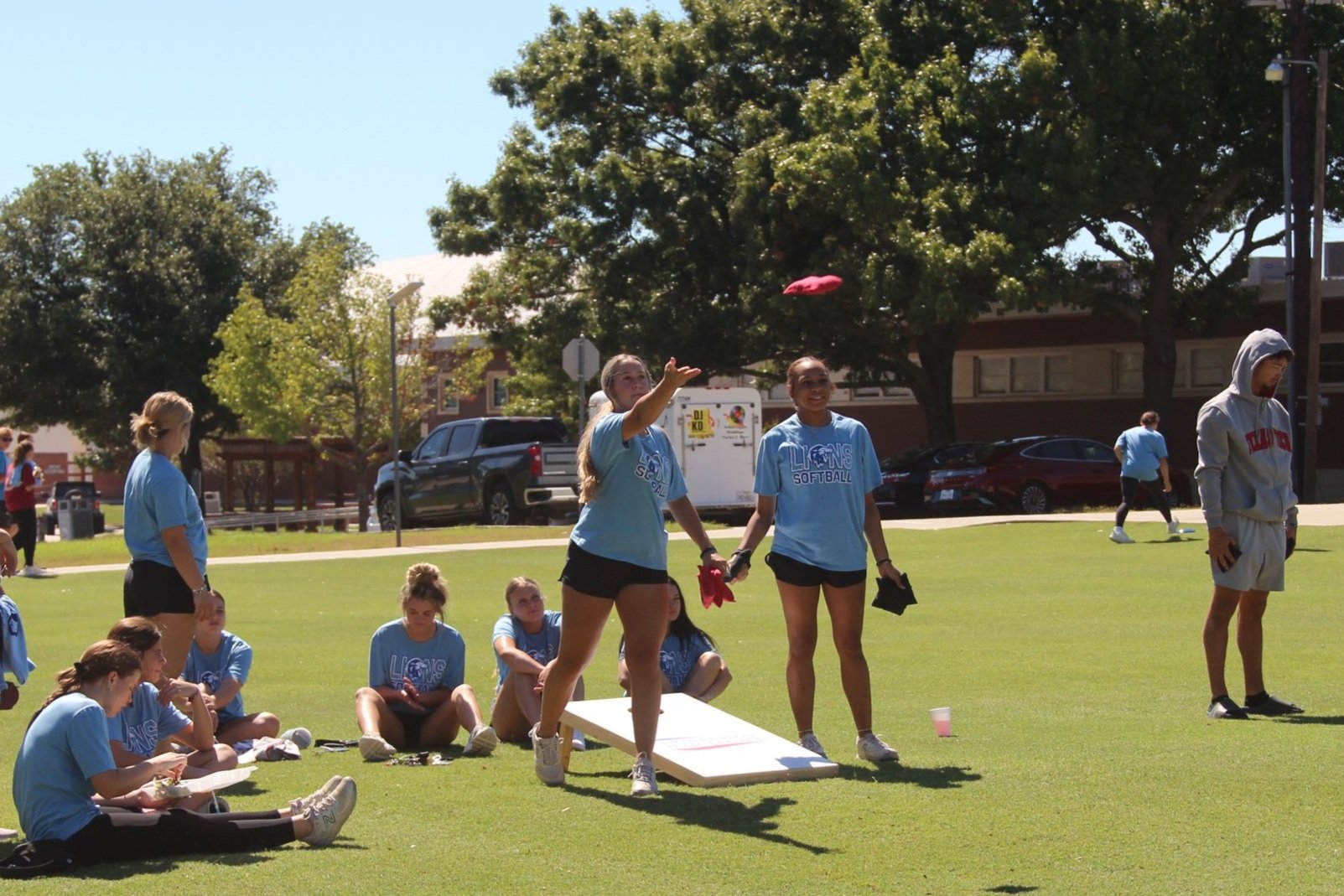 students playing cornhole game on gainesville campus lawn